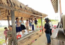 យុវតី ២រូប ដែលជាគ្រូបង្រៀនស្ម័គ្រចិត្តនៃសមាគម«ទុកចិត្ត» ឈរបង្រៀនកុមារតូចៗនៅស្នាក់ការរបស់សមាគម ក្នុងស្រុកឈូក ខេត្តកំពត កាលពីថ្ងៃទី២៨ ខែមករា ឆ្នាំ២០២៣។