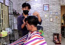 លោ​​ក វឹង រត្ននៈ កាត់សក់ជូនអតិថិជនដែលមកទទួលសេវា នៅខេត្តកំពង់ចាម។